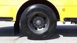 A close-up of a black Goodyear tire mounted on a silver alloy wheel featuring multiple lug nuts and a smooth surface