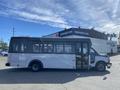 A white 2017 Chevrolet Express shuttle bus with large windows and an open side door