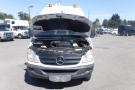 A 2012 Mercedes-Benz Sprinter with the hood raised showcasing the engine compartment and front grille with the Mercedes emblem