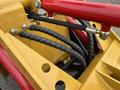 A close-up view of the hydraulic system featuring red and black hoses and connectors on a 2024 AGT Industrial KRW23 Mini Loader