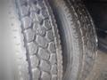 Close-up of two worn tires on a truck showcasing distinct tread patterns and visible wear on the rubber surface