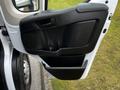 A black interior door panel of a 2021 RAM Promaster featuring a speaker and a storage compartment