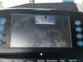 Display screen showing a rearview camera image of a vehicle behind a 2009 Spartan Gladiator with blue buttons and various control labels visible