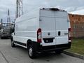 A white 2021 RAM Promaster cargo van is parked with its rear facing the viewer featuring a smooth design and no visible cargo in the back
