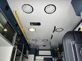 Interior ceiling of a 2013 Chevrolet Express with several round lights and a ventilation unit visible along with ventilation ducts and handrails