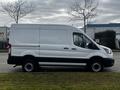 A 2020 Ford Transit van in white color with a high roof and sliding side door view from the side