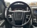 Steering wheel and dashboard of a 2014 Ford F-150 displaying gauges and control buttons