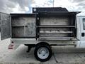 A 2007 Ford F-550 with an open service bed showcasing multiple shelves and compartments for tools and equipment