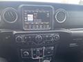 Interior dashboard of a 2020 Jeep Wrangler featuring a touchscreen display with radio controls and climate settings