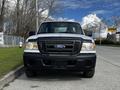 A 2010 Ford Ranger parked on the side of the road facing forward with visible headlights and a black grille