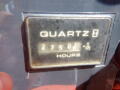 A close-up view of a quartz hour meter displaying 2750.6 hours with a faded and worn appearance