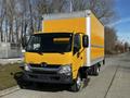 A 2017 Hino 155 box truck with a bright yellow cargo area and a gray front cab parked at a roadside