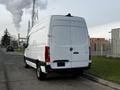 A 2022 Mercedes-Benz Sprinter parked on the street showcasing a white exterior and spacious cargo area with a high roof design