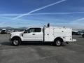 A 2017 Ford F-350 SD in white with a utility bed and equipment storage compartments parked on a lot