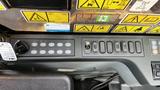 Control panel of a 2018 Caterpillar 326F L Excavator featuring various buttons and a dial