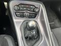 The image shows the gear shift and control panel of a 2017 Dodge Challenger featuring a manual transmission and various buttons for climate and audio settings