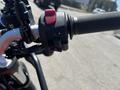 A close-up of the right handlebar of a 2022 Royal Enfield Himalayan showing the controls with a red switch and a grip texture