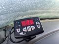 A digital temperature display unit with red numbers indicating temperature settings and buttons for Celsius and Fahrenheit on a dashboard