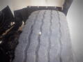 A close-up of a worn tire on a 2016 International WorkStar 7500 showing visible tread wear and a small nail embedded in the rubber