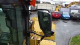 A 2019 Caterpillar 972M XE wheel loader with a visibility mirror and control panel visible in the foreground