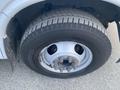 Close-up of a tire mounted on a wheel from a 2017 Chevrolet Express showing tread pattern and metal lug nuts