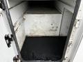 An empty and dirty interior of a compartment from a 2013 Ford F-650 with visible stains and a dark floor