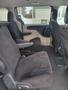 Interior view of a 2012 Dodge Grand Caravan showing two front seats with black fabric upholstery and armrests