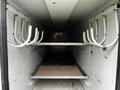 Interior view of a 2013 Ford F-650 truck with two metal shelves and multiple white hooks attached to the walls