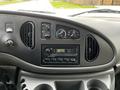 Dashboard of a 2004 Ford Econoline featuring air conditioning controls a stereo system and various knobs and buttons for vehicle operation