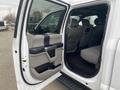 Interior view of a 2019 Ford F-150 showing the passenger side door open with beige upholstery and seating visible in the back