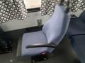 Interior view of a blue upholstered driver's seat in a 2012 Chevrolet Express with armrests and a adjustable base