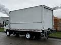A 2018 Hino 195 truck with a white cargo box and flatbed, featuring a sleek design and large wheels, viewed from the side