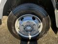 Close-up of the wheel of a 2014 Mitsubishi Fuso FE featuring silver alloy rims and a black tire with visible tread pattern