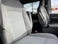 Interior view of a 2014 Ford Econoline showing two gray cloth front seats with a simple design and seatbelts