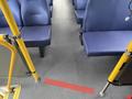 Interior view of a 2017 Chevrolet Express showing blue upholstered seats and yellow handrails on either side of the aisle