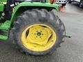 A close-up of a large tractor tire mounted on a yellow rim with the brand name Titan visible on the sidewall