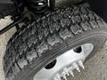 A close-up of a tire from a 2009 Ford F-550 showing detailed tread pattern and silver wheel rim