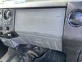 The dashboard of a 2013 Ford F-250 SD featuring the embossed text "SUPER DUTY" and several control buttons and knobs