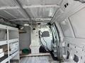 Interior of a 2008 Ford Econoline van featuring metal shelving units and a partition divider with a vintage design