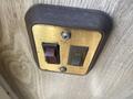 A vintage gold and black toggle switch panel featuring a red indicator light and two switches labeled CH and OFF