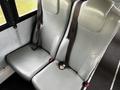 Two grey upholstered bus seats with seatbelts attached