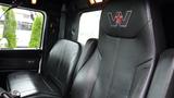 Interior of a 2019 Western Star Trucks 4900 featuring black leather seats with a logo of a star and the letter W embroidered on the backrest