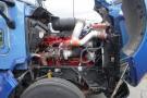 A 2015 Kenworth T660 truck with the engine compartment open displaying a red engine with large pipes and a black intake manifold