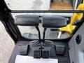 Interior view of a 2024 Caterpillar 306 showing two joystick controls and foot pedals for operation