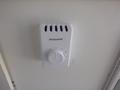 A Honeywell thermostat mounted on a white wall with a round dial for temperature adjustment