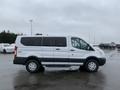 A white 2017 Ford Transit van parked, featuring a sliding side door and aluminum wheels