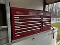 A red tool chest with multiple drawers labeled for different tools including drills and wrenches
