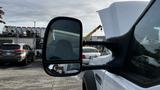 A 2007 Ford F-550 truck with a focus on the side mirror reflecting the driver and surroundings