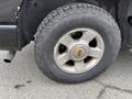 A close-up view of a 2004 Ford Explorer Sport Trac tire with a Hercules brand tire and a silver wheel rim showing wear and some rust