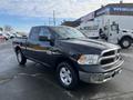 A black 2015 RAM 1500 pickup truck with a front grille featuring the RAM logo and chrome accents parked at an outdoor location